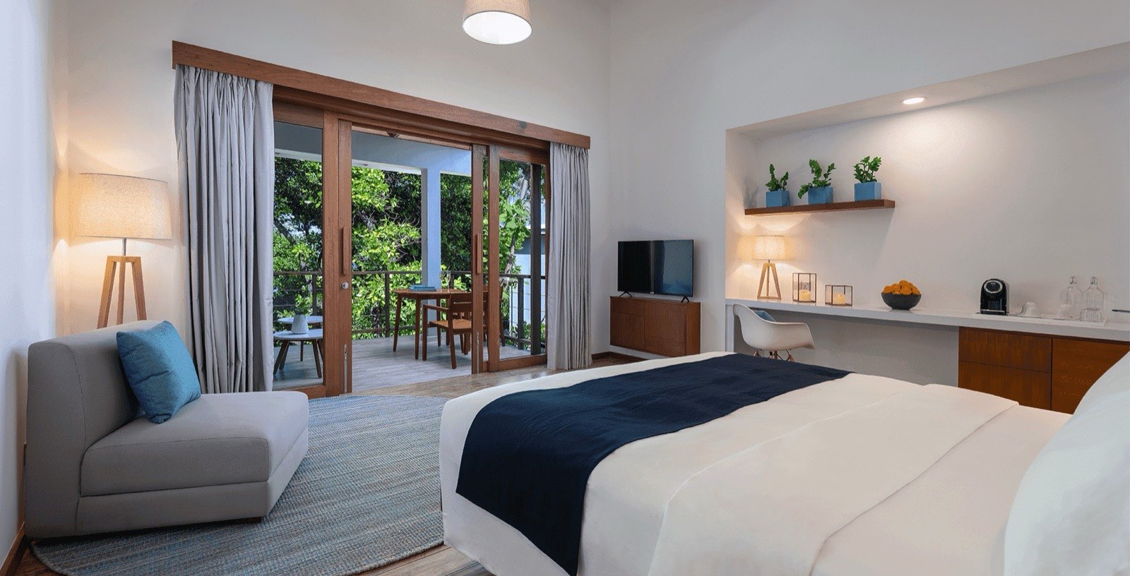Bedroom of a Sunset Sky Suite, with a large bed and light timber and white finishes.